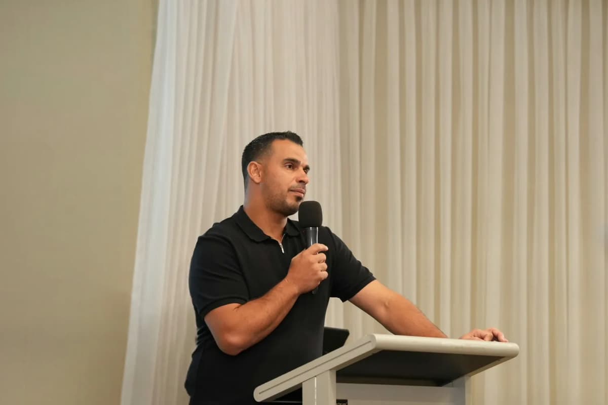 Pastor Rabeeh preaching at the lectern during an HSHW service in Merrylands